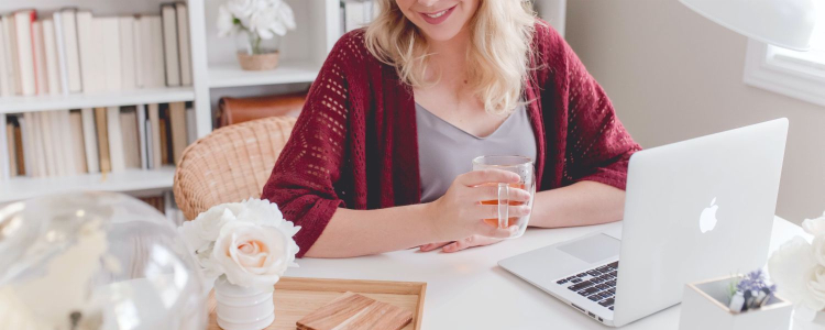 woman smiles at her nicely appointed corporate office; she's made it a nice place to be