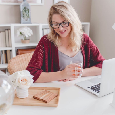 woman smiles at her nicely appointed corporate office; she's made it a nice place to be