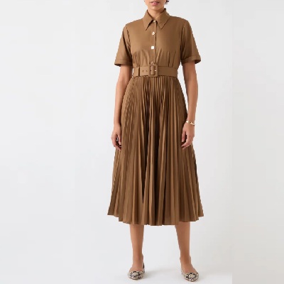 A woman wearing a brown shirtdress and croc-print flats