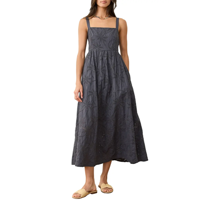 woman wears dark gray sundress with small rosette eyelet patterns on it