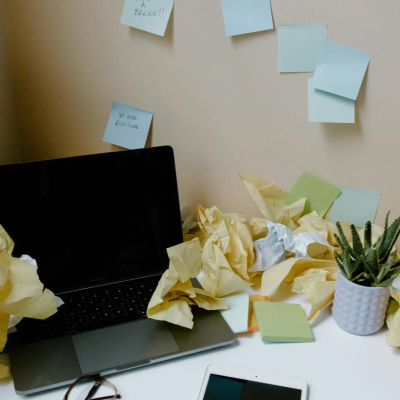 messy office with haphazard post-it notes and discarded papers