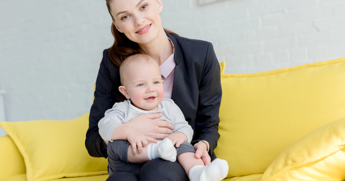 happy woman in interview suit holds a baby; it's going to be a strange interview experience