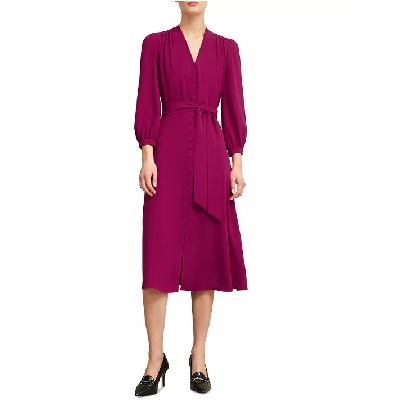 A woman wearing a fuchsia long sleeve dress with black heels