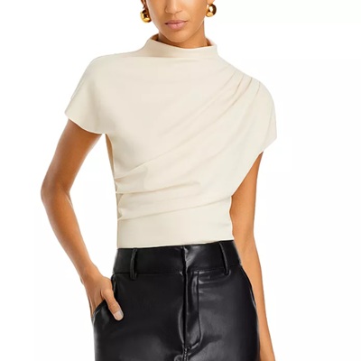 A woman wearing an ecru top with black leather pants