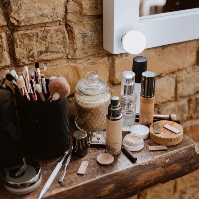 lotions and serums sit on a wooden counter in front of a light; they just might be beauty products bought on repeat