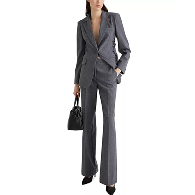 woman wears gray suit with lacing/corset details along back and sides of blazer