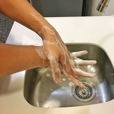 woman washes her hands in sudsy soap