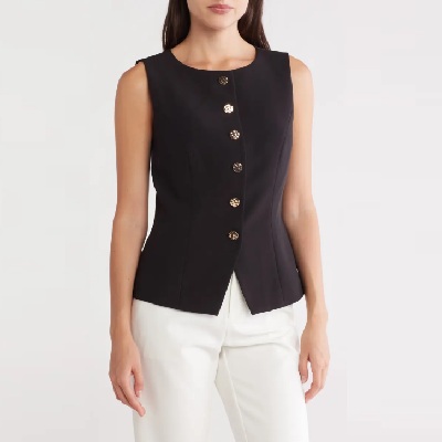 A woman wearing a black vest with white pants