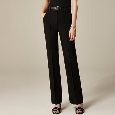A woman wearing a pair of black pants with black sandals
