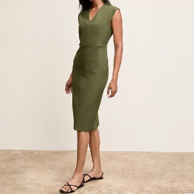 A woman wearing a bright olive sleeve less silk dress with flat sandals