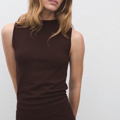 A woman wearing a brown sleeveless knit top
