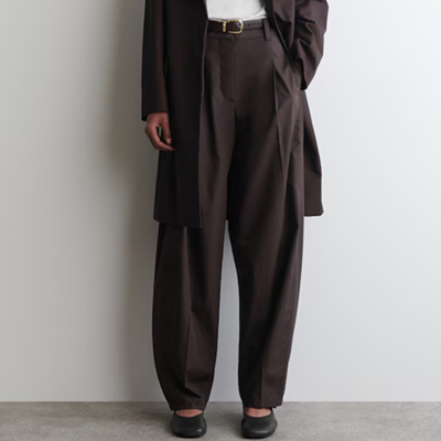 woman wears brown barrel leg pants with round toe shoes