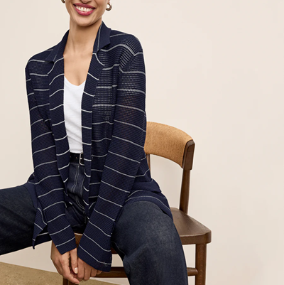 woman wears stripey jardigan with jeans; it is double-breasted and slightly sheer