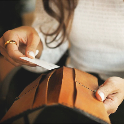 woman opens brown wallet with a long shape but no zipper