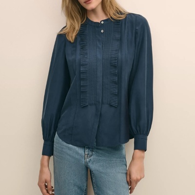 A woman wearing a dark blue long sleeve polo blouse and denim pants