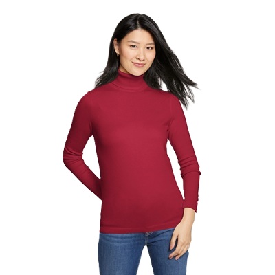 A woman wearing a wine-colored turtleneck and blue jeans