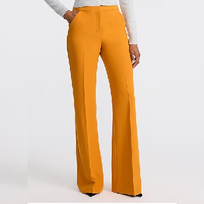 A woman wearing a dark orange high waist flare trouser pants