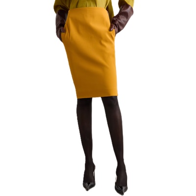A  woman wearing a yellow blouse, mustard yellow skirt, black stockings, and black heels