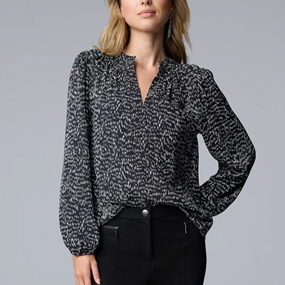 A woman wearing a black white long sleeve neck blouse top