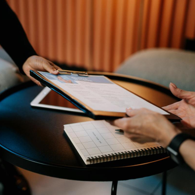 woman hands someone her resume; she made it using the best resume templates for lawyers