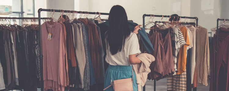 woman looks at clothing rack; she is trying to level up her personal style