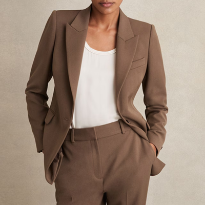 woman wears light brown suit