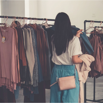 woman looks at clothing rack; she is trying to level up her personal style