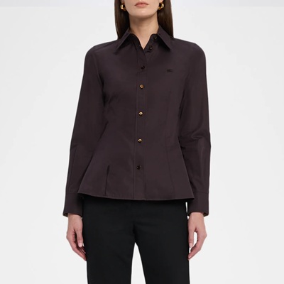 A woman wearing a brown button-front shirt and black pants