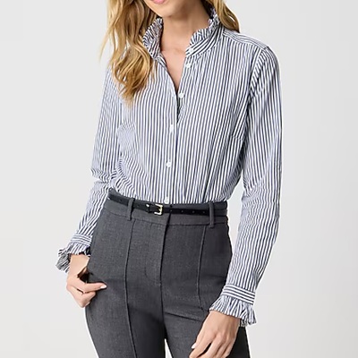 A woman wearing black white polo top with gray trouser pants and black belt