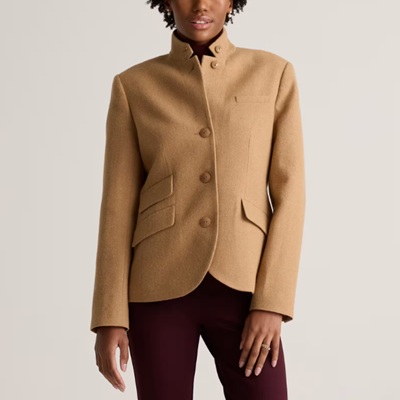 A woman wearing a brown collar blazer with maroon pants