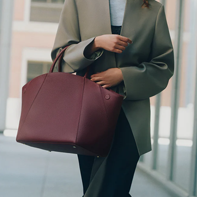 woman carries large burgundy work bag