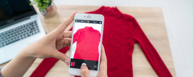 woman photographs red turtleneck sweater in order to sell business clothes online