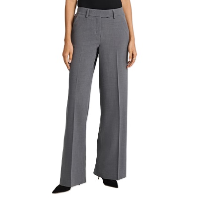 A woman wearing a black top, gray pants, and black heels (shown from the waist down)