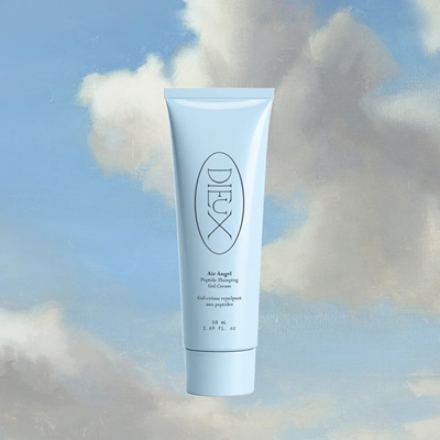 A bottle of Dieux plumping gel cream in front of a background of a blue sky with clouds