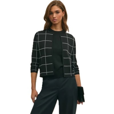 A woman wearing a black-and-white windowpane cardigan, black top, and black pants