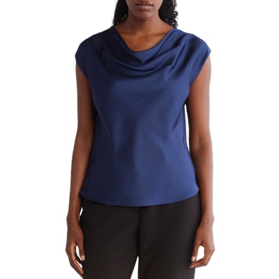 A woman wearing black pants and a navy sleeveless cowl-neck top