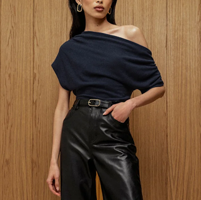 woman wears navy with black; her top is falling off her shoulder