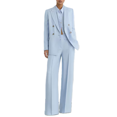 woman wears double-breasted light blue suit with wide legs; her blouse has the top few buttons buttoned but gapes open at the waist (?)