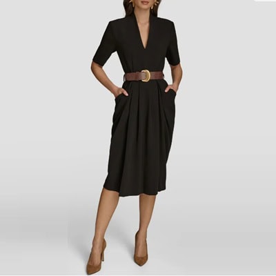 A woman wearing a black dress with brown belt and brown heels