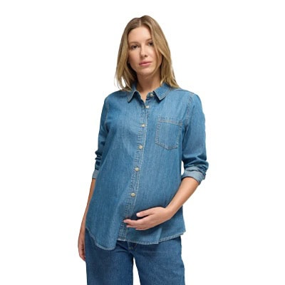 A pregnant woman wearing a blue denim button-front shirt and darker blue jeans
