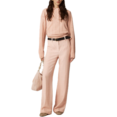 Woman wears pale pink pants and pale pink sweater