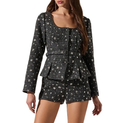 A woman wearing a gray sequined jacket and shorts set