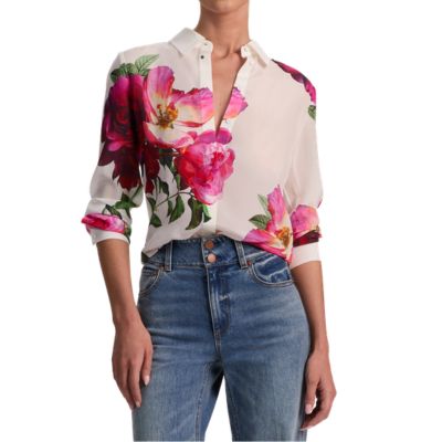 A woman wearing a floral blouse and blue jeans