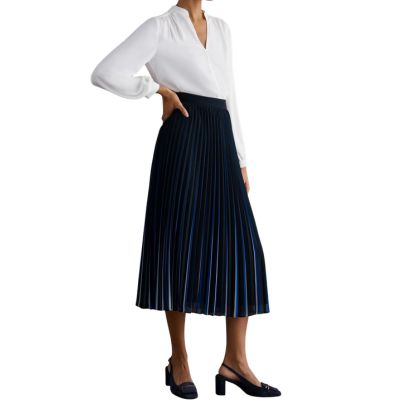 A woman wearing a white blouse and blue midi skirt with black slingbacks