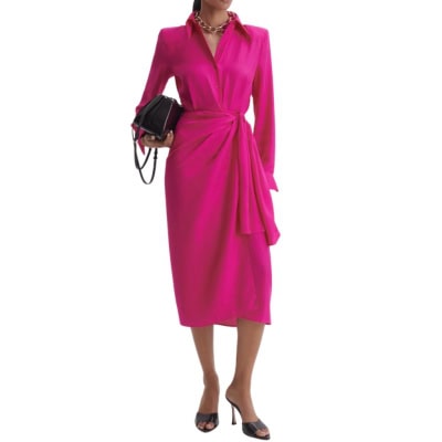 A woman wearing a pink wrap dress, gold chain necklace, and black heels. She is carrying a black handbag.