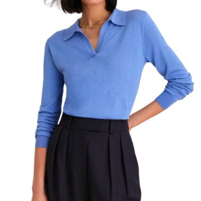 A woman wearing a blue polo sweater and black pants