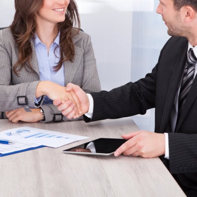 young professional woman (possibly a summer associate or law firm intern) shaking hands with an older man in a suit