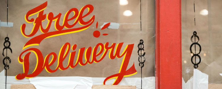 store window has hand painted (?) sign that says "free delivery"