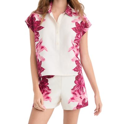 A woman wearing a white-and-pink floral top and matching shorts