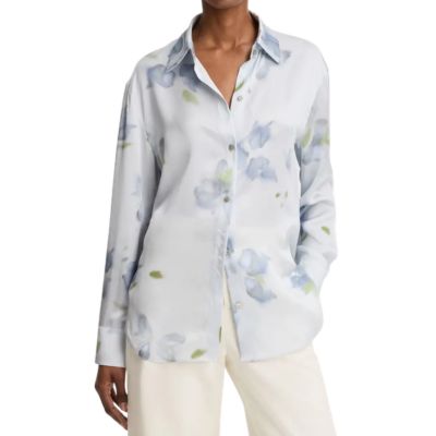 A woman wearing a blue floral blouse and cream-colored pants